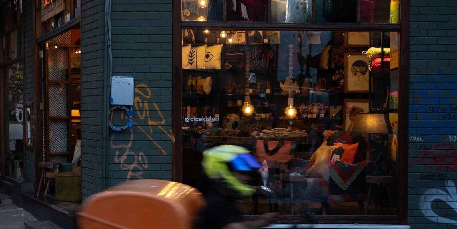 A-man-riding-a-bike-down-a-street-past-a-store-scaled.jpg